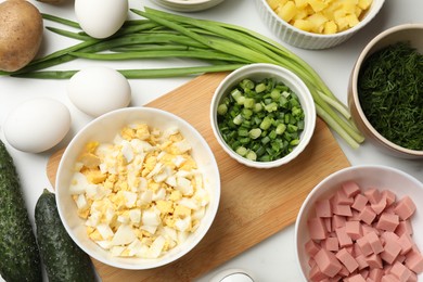 Photo of Different ingredients for okroshka soup on white table, flat lay