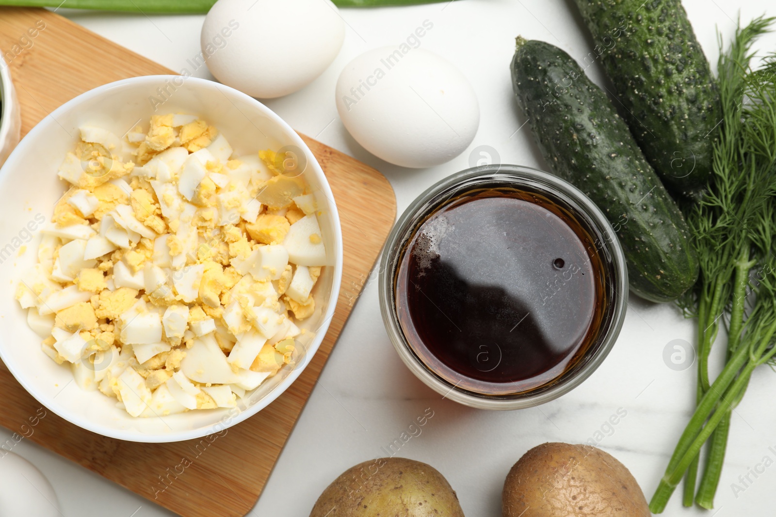 Photo of Different ingredients for okroshka soup on white table, flat lay