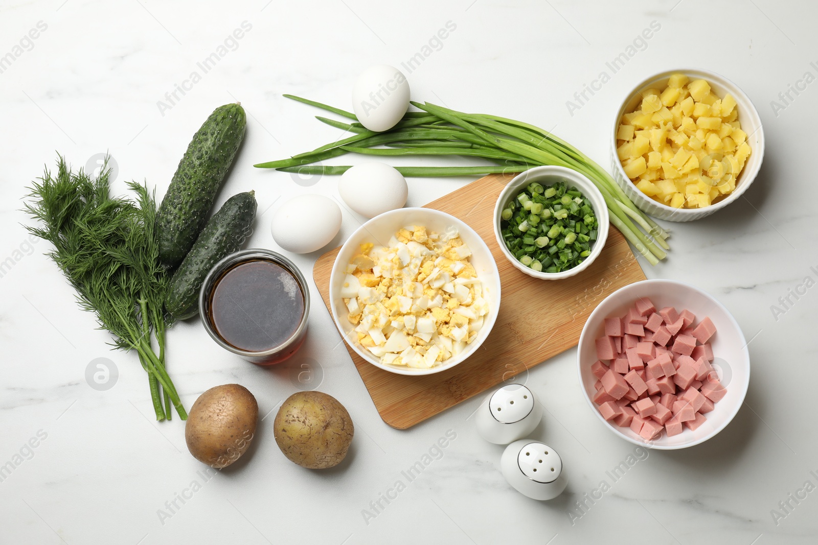 Photo of Different ingredients for okroshka soup on white table, flat lay