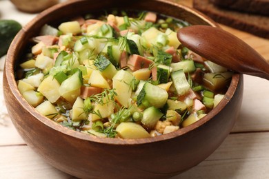 Photo of Delicious okroshka soup with kvass and ingredients on white wooden table, closeup