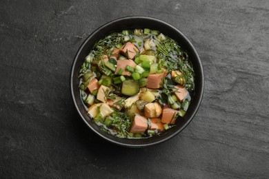 Photo of Delicious okroshka soup with kvass on black table, top view