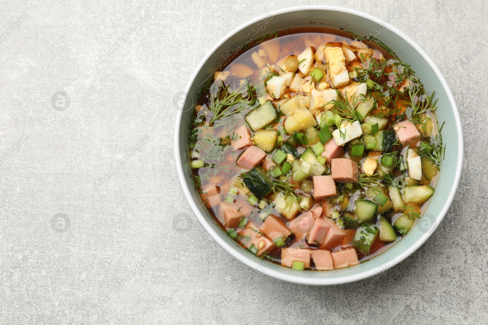 Photo of Delicious okroshka soup with kvass on light table, top view. Space for text