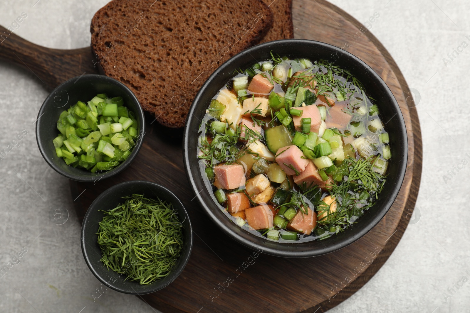 Photo of Delicious okroshka soup with kvass and ingredients on light table, top view