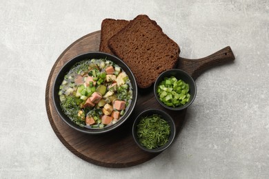 Photo of Delicious okroshka soup with kvass and ingredients on light table, top view