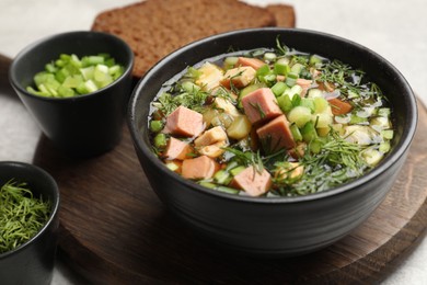 Photo of Delicious okroshka soup with kvass and ingredients on light table, closeup