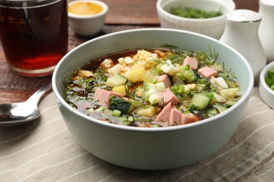 Photo of Delicious okroshka soup with kvass served on table, closeup