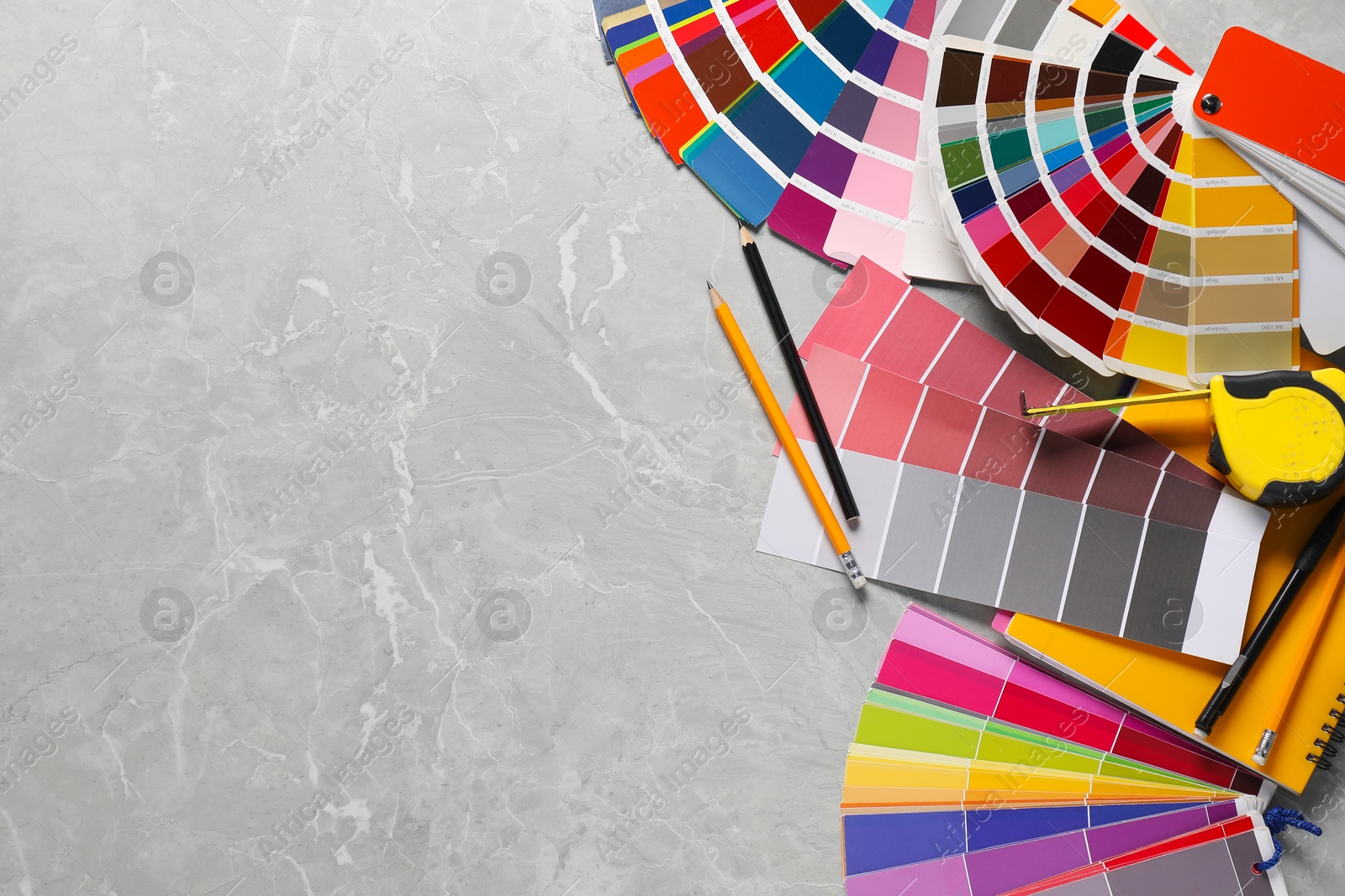 Photo of Different painter's tools on grey marble table, flat lay with space for text. Decorating and design