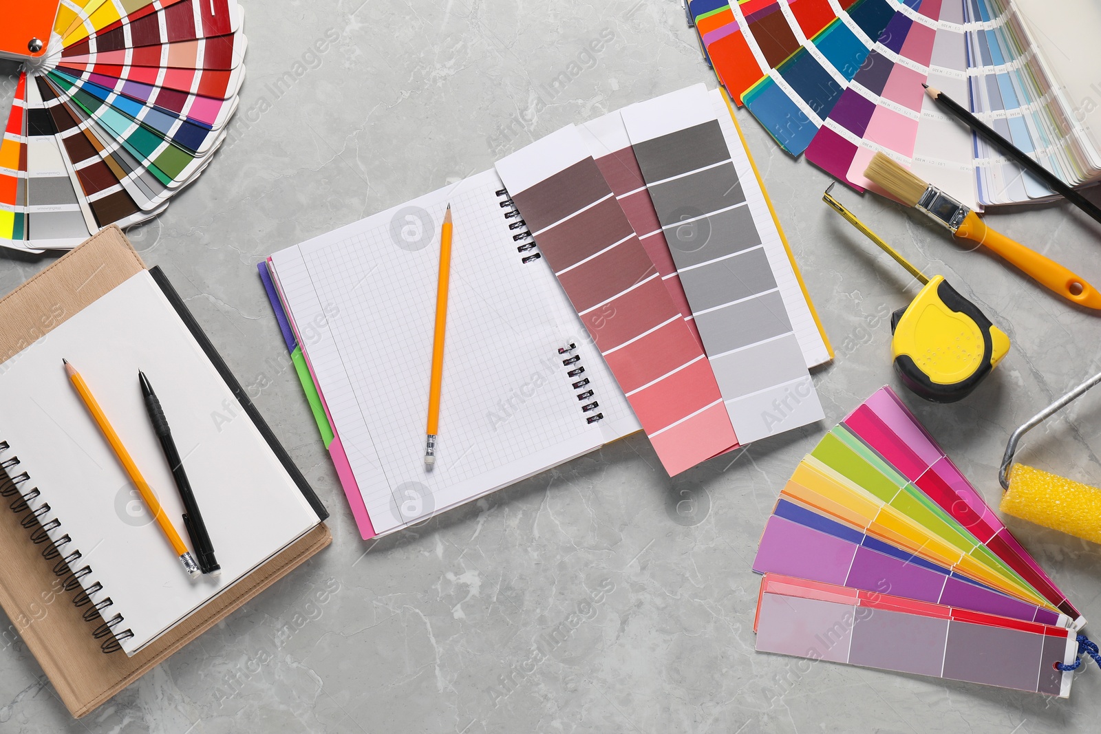 Photo of Different painter's tools on grey marble table, flat lay with space for text. Decorating and design