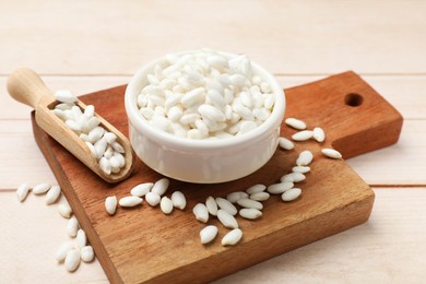 Photo of Bowl and scoop with puffed rice on white wooden table