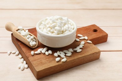 Photo of Bowl and scoop with puffed rice on white wooden table