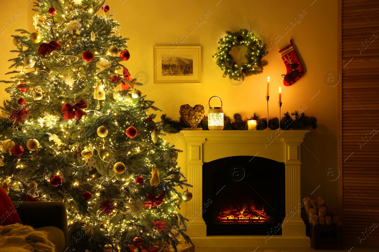 Photo of Decorated Christmas tree near fireplace in room. Festive interior design