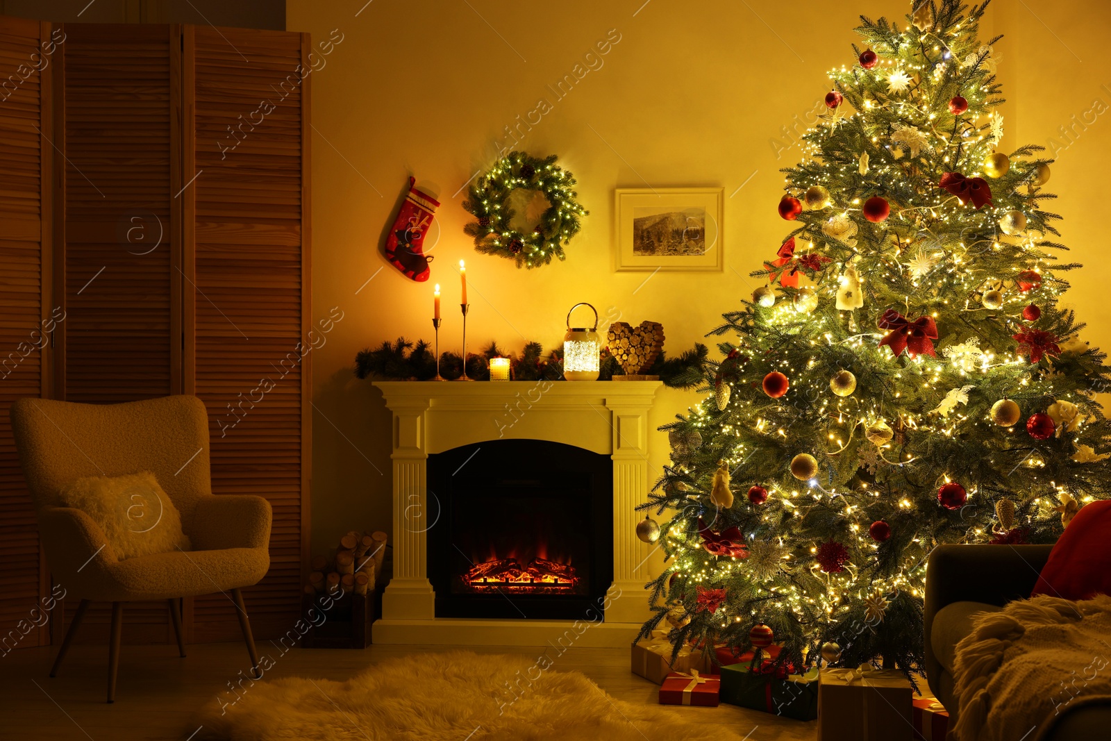 Photo of Decorated Christmas tree near fireplace in room. Festive interior design