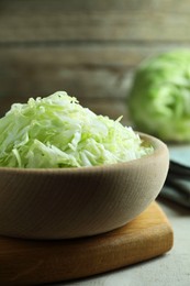 Photo of Fresh shredded cabbage on light table, closeup