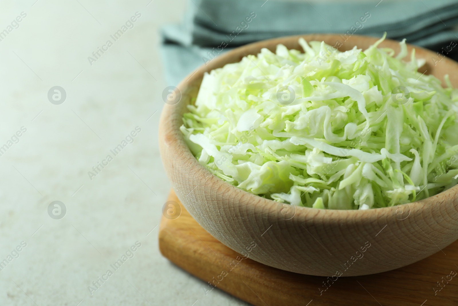 Photo of Fresh shredded cabbage on light table, closeup. Space for text