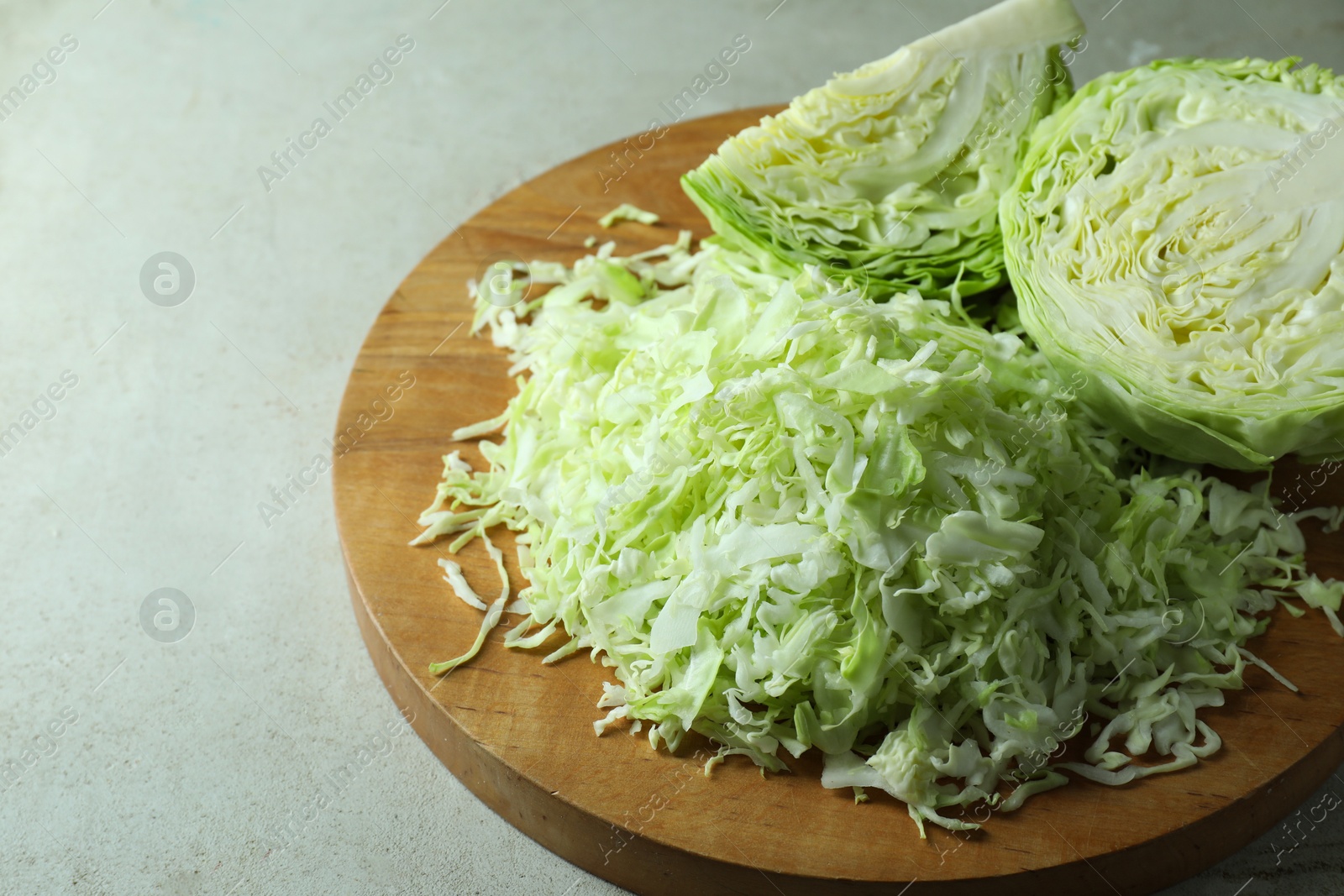 Photo of Fresh shredded cabbage on light table, closeup