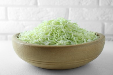 Photo of Fresh shredded cabbage on light table, closeup