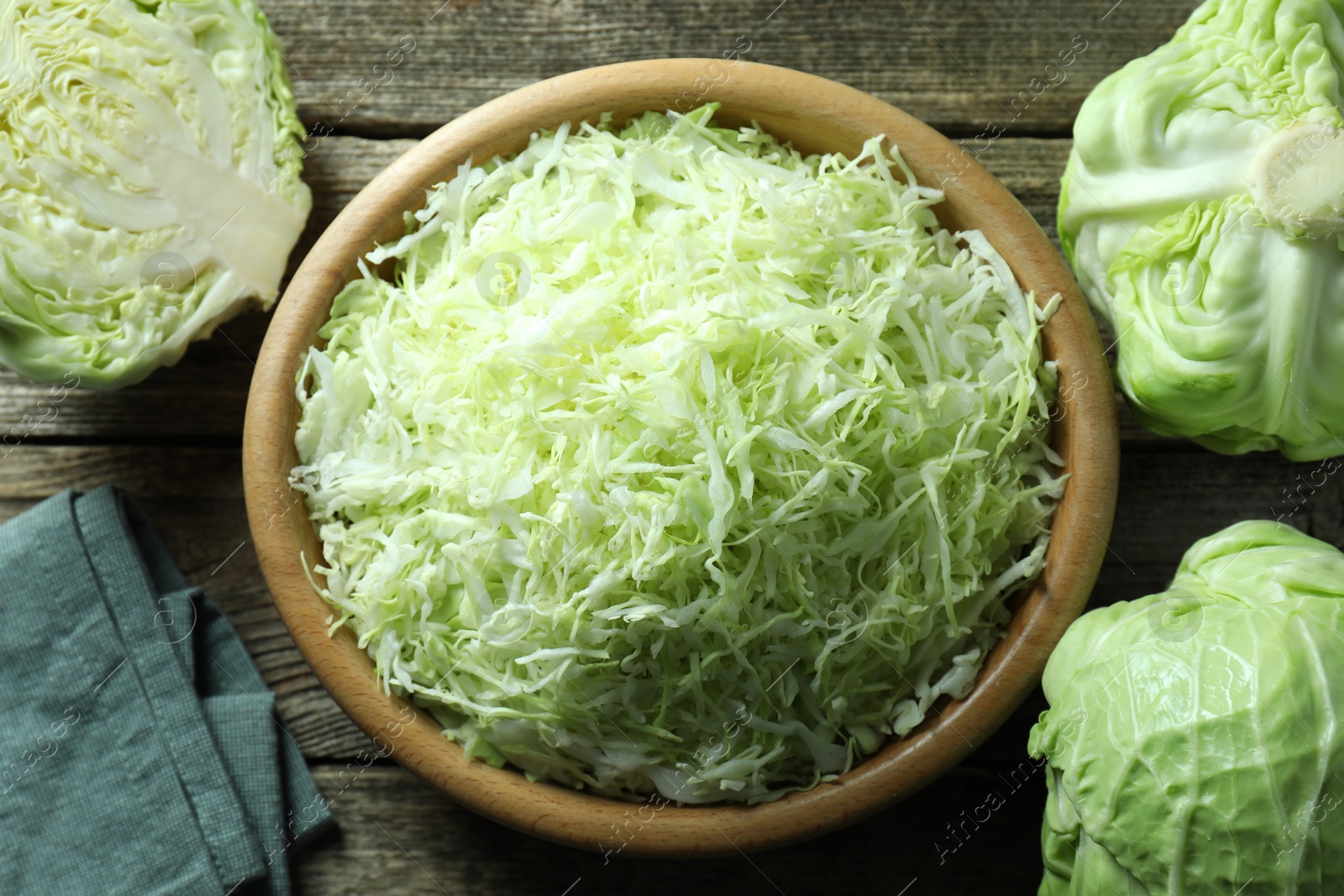 Photo of Fresh shredded cabbage on wooden table, flat lay