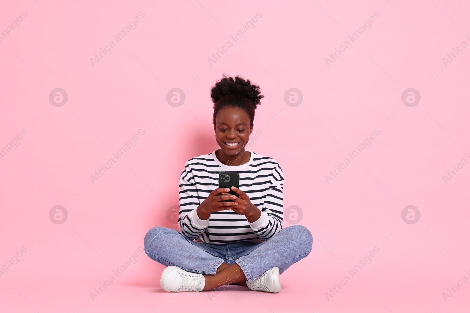 Photo of Happy woman with smartphone on pink background