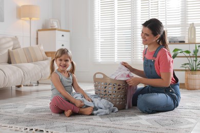 Little helper. Daughter and her mother with laundry at home