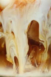 Photo of Refreshing coffee with ice and milk as background, closeup