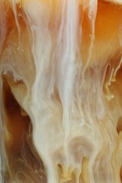 Photo of Refreshing coffee with ice and milk as background, closeup