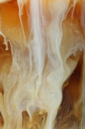 Photo of Refreshing coffee with ice and milk as background, closeup