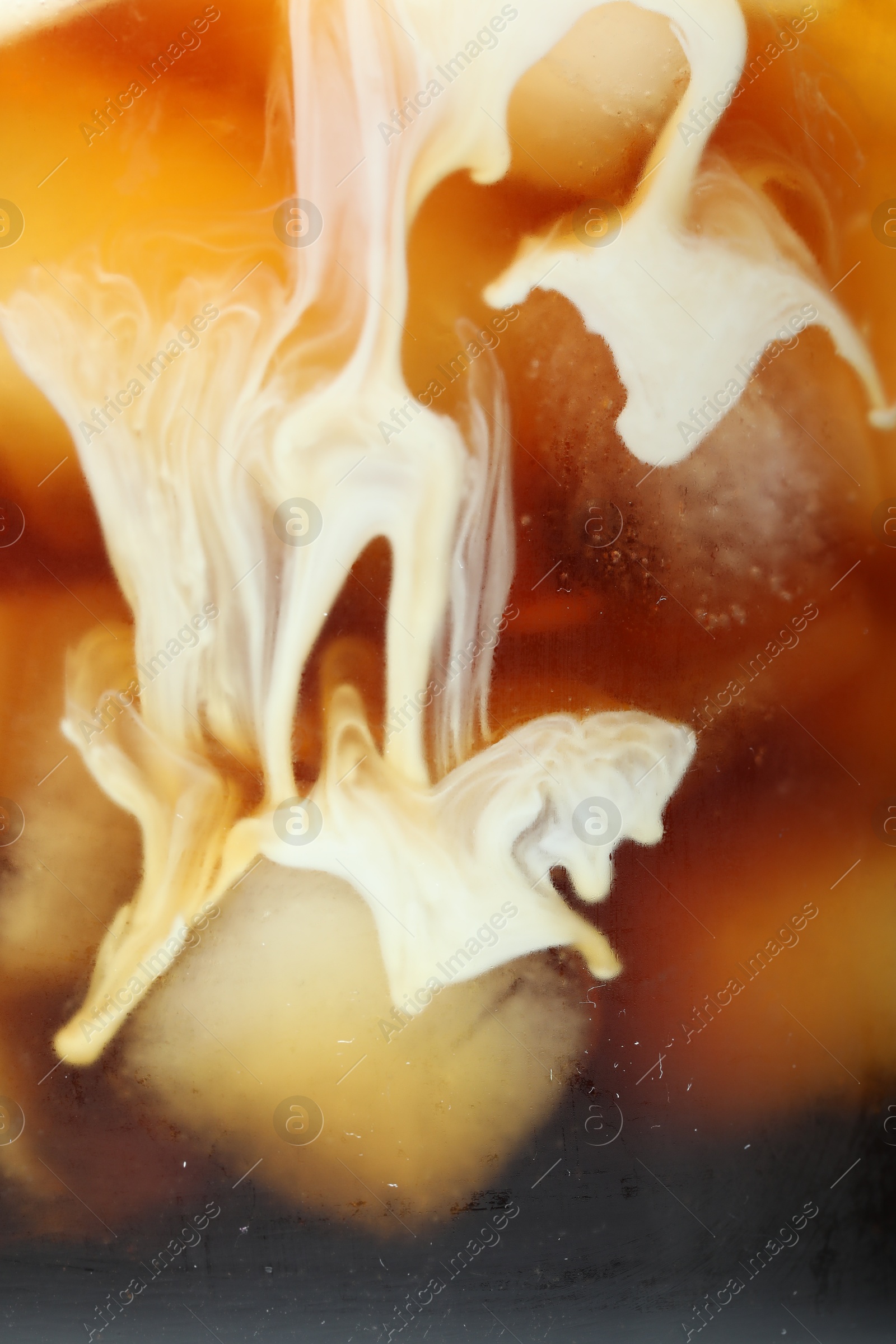 Photo of Refreshing coffee with ice and milk as background, closeup