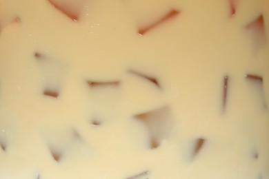 Photo of Refreshing coffee with ice and milk as background, closeup