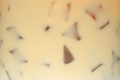 Photo of Refreshing coffee with ice and milk as background, closeup