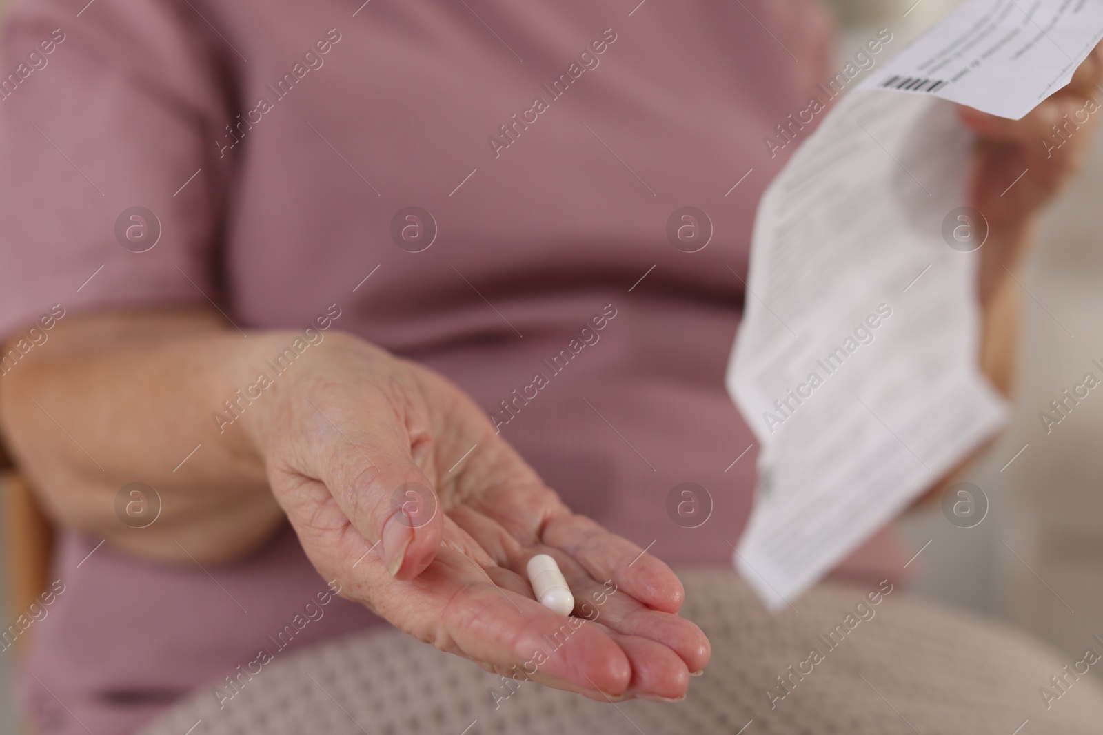 Photo of Senior woman with medical instruction and pill, closeup