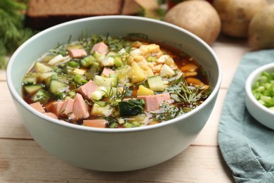 Photo of Delicious okroshka soup with kvass and ingredients on white wooden table, closeup