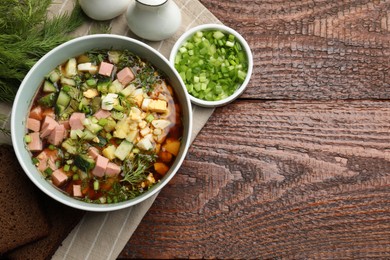 Photo of Delicious okroshka soup with kvass served on wooden table, top view. Space for text