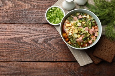 Photo of Delicious okroshka soup with kvass served on wooden table, top view. Space for text