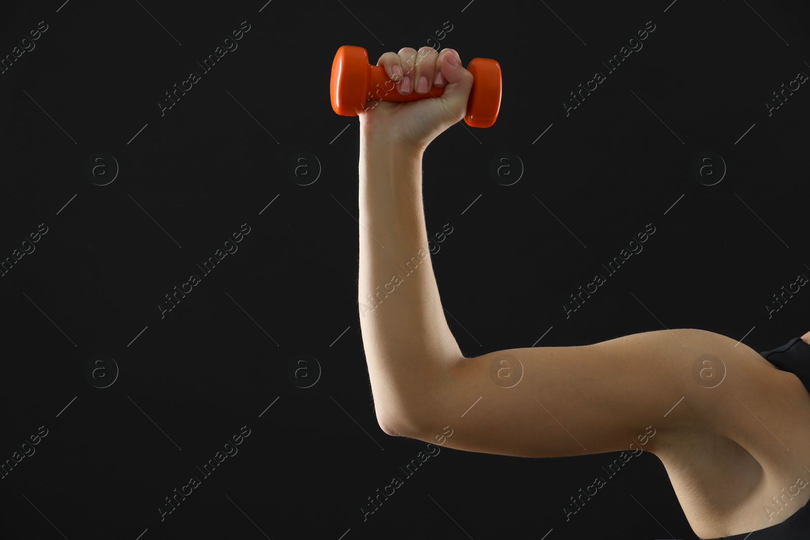 Photo of Woman exercising with dumbbell on black background, closeup. Space for text