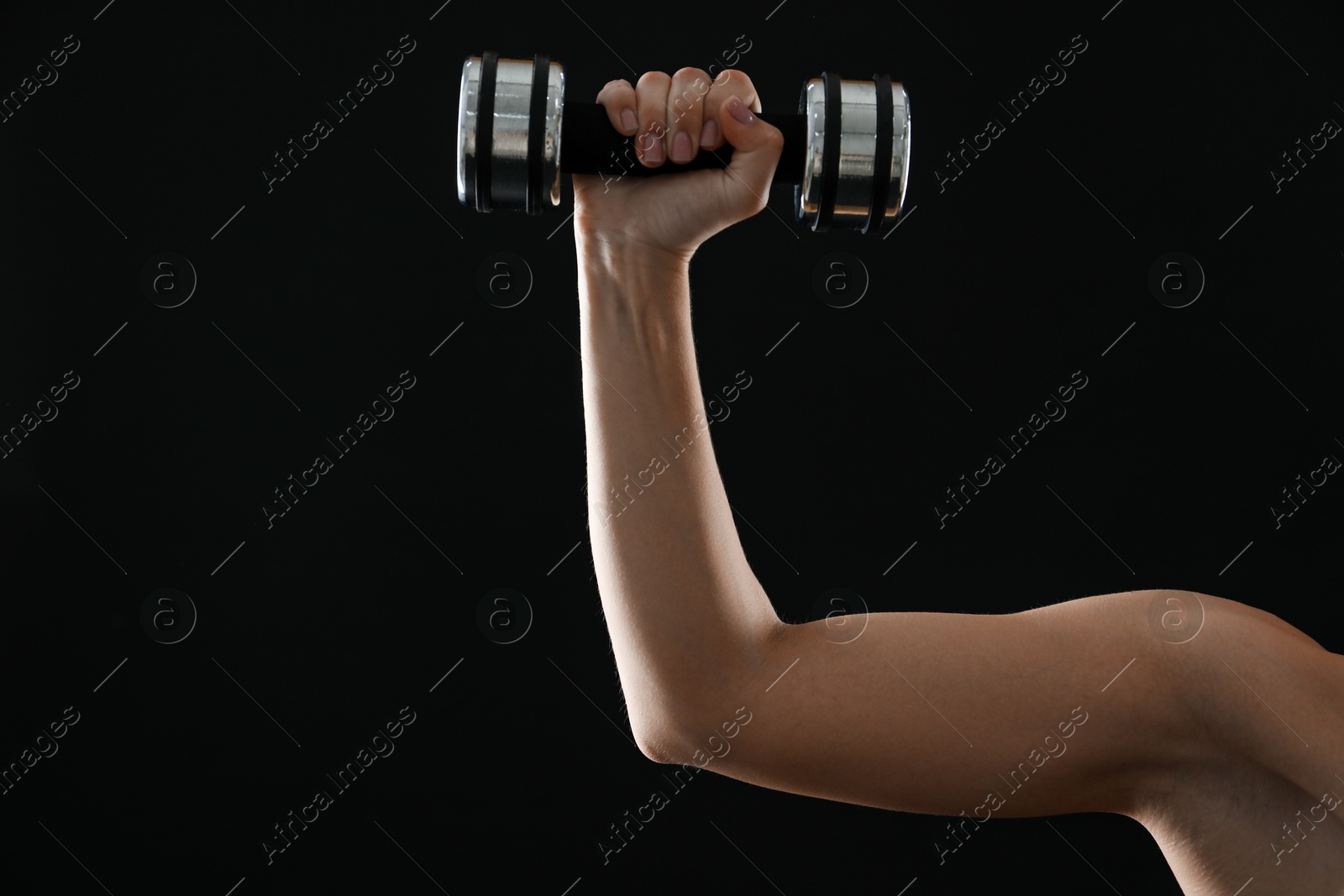 Photo of Woman exercising with dumbbell on black background, closeup. Space for text