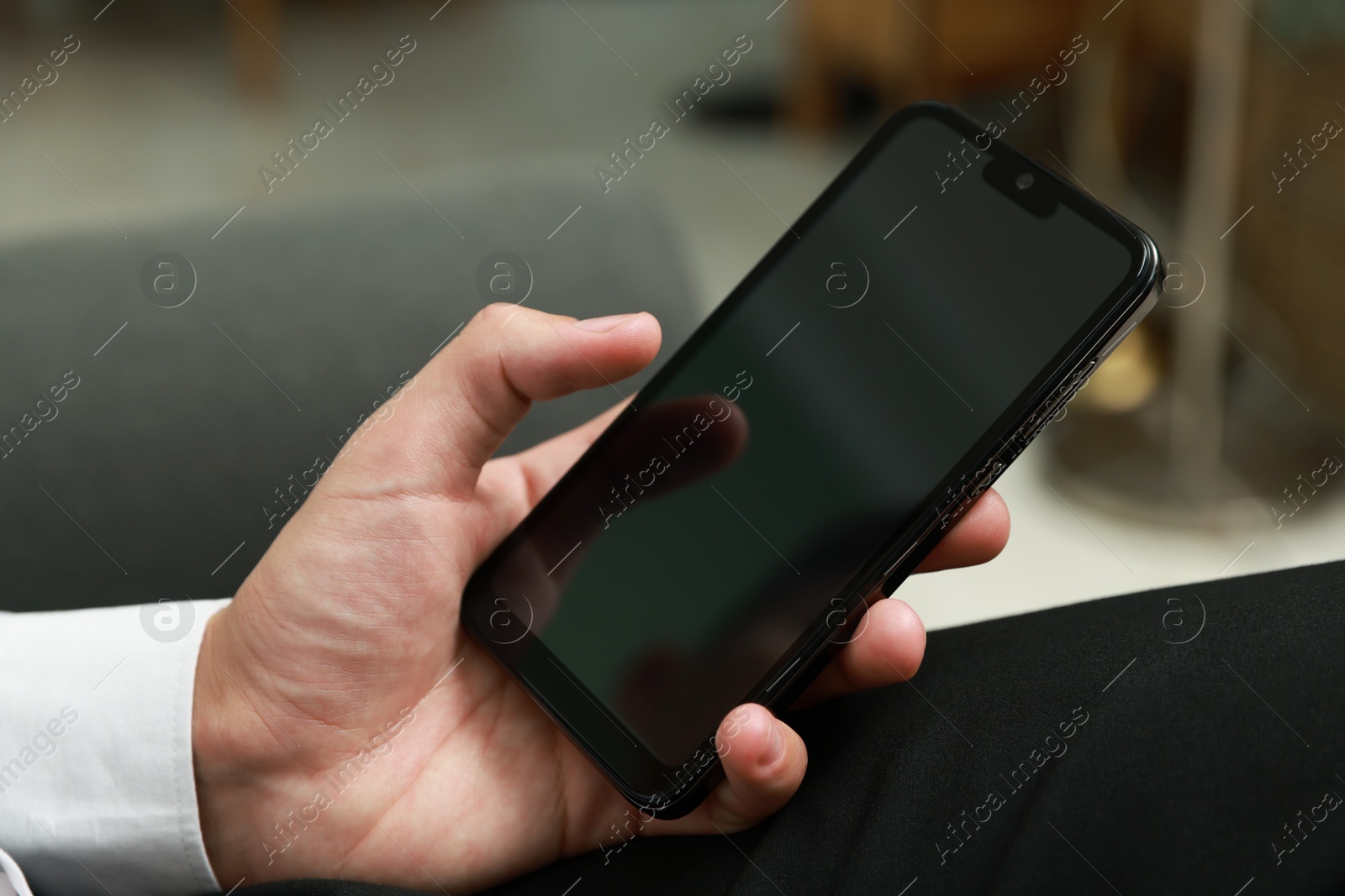 Photo of Man using smartphone with blank screen indoors, closeup