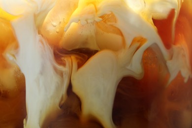 Photo of Refreshing coffee with ice and milk as background, closeup