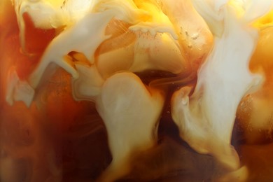 Photo of Refreshing coffee with ice and milk as background, closeup