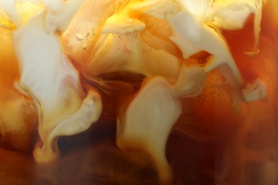 Photo of Refreshing coffee with ice and milk as background, closeup