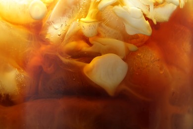 Photo of Refreshing coffee with ice and milk as background, closeup