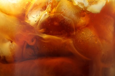 Photo of Refreshing coffee with ice and milk as background, closeup