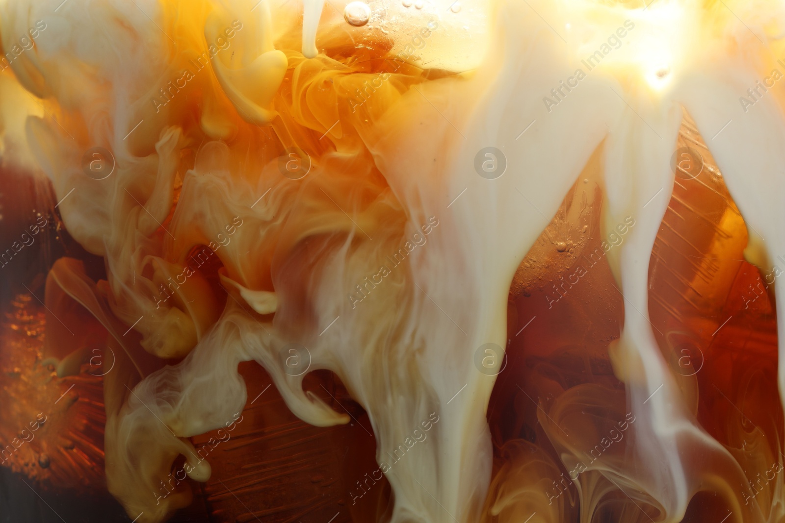 Photo of Refreshing coffee with ice and milk as background, closeup