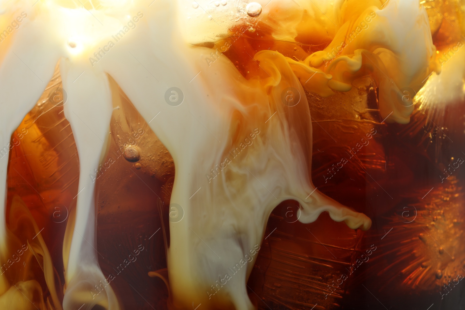 Photo of Refreshing coffee with ice and milk as background, closeup