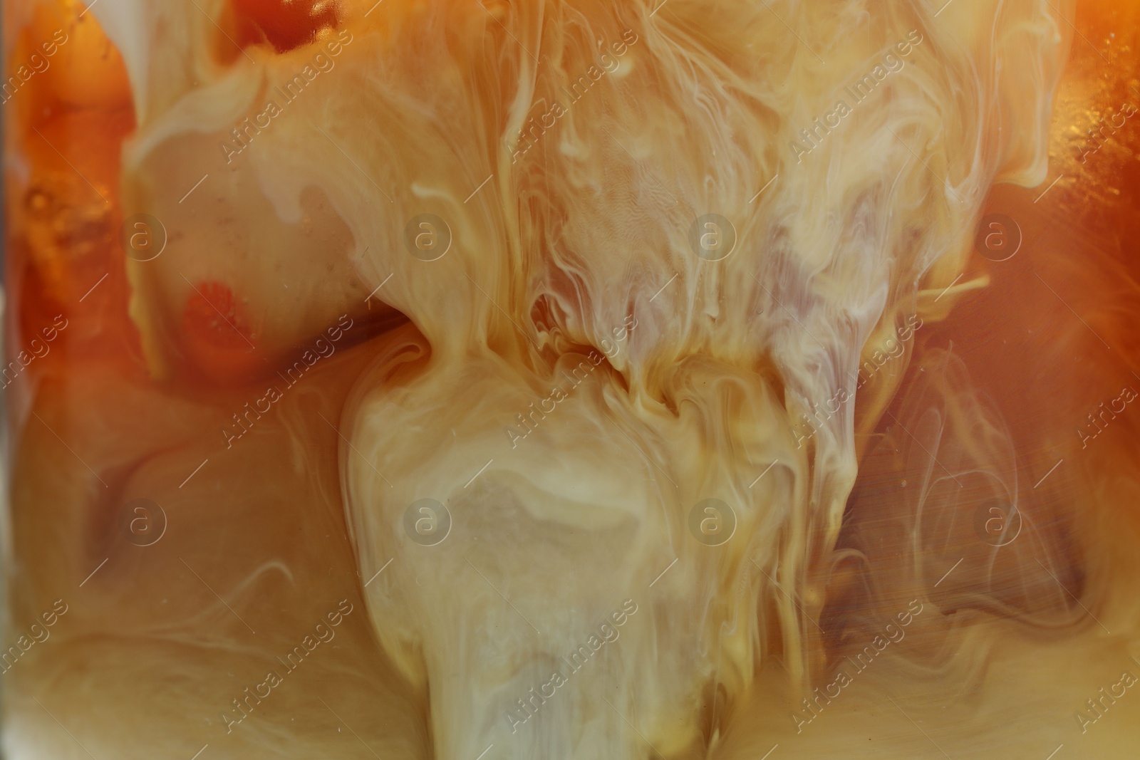 Photo of Refreshing coffee with ice and milk as background, closeup