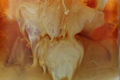 Photo of Refreshing coffee with ice and milk as background, closeup