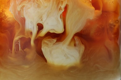 Photo of Refreshing coffee with ice and milk as background, closeup