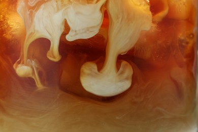 Photo of Refreshing coffee with ice and milk as background, closeup