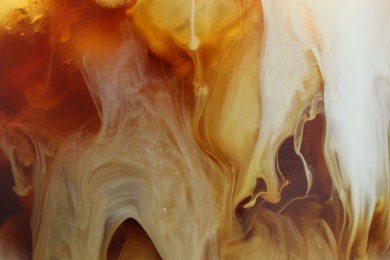 Photo of Refreshing coffee with ice and milk as background, closeup