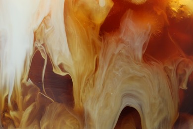 Photo of Refreshing coffee with ice and milk as background, closeup