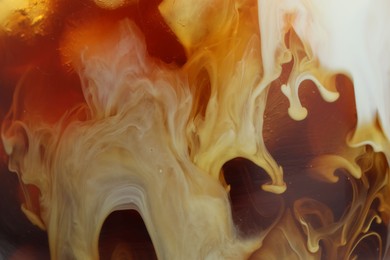 Photo of Refreshing coffee with ice and milk as background, closeup